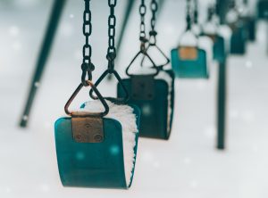 green children's swings in the snow